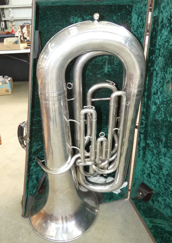 A large silver tuba in an open green-lined case.