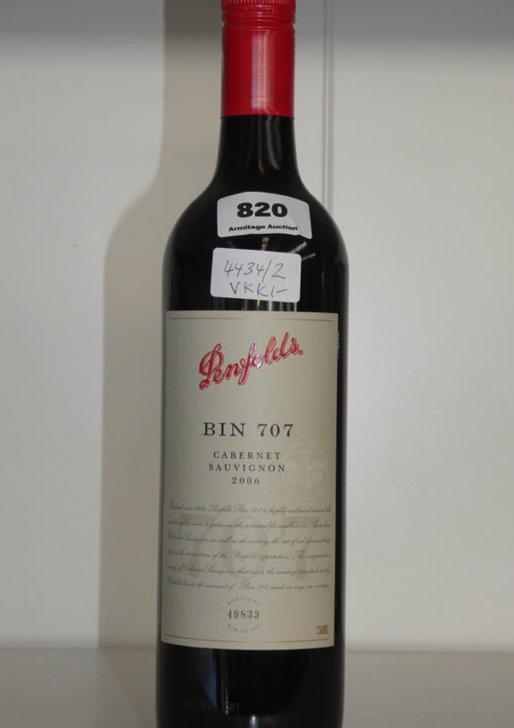 A bottle of Tall Ships rum with a cork stopper, featuring a label with a ship illustration and a metal cannon decoration at the bottom. The bottle has a light brown liquid inside and is marked with the number 636.