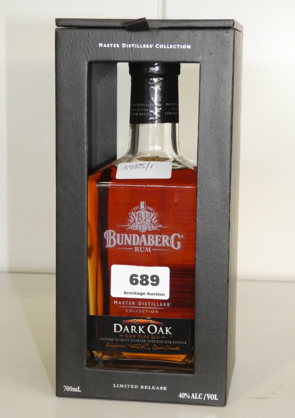 A bottle of Bundaberg Dark Oak rum in a black box with a transparent front, displaying a label with the number 689.